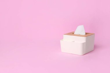 Pembe arka planda kağıt mendilleri olan tutucu. Metin için boşluk