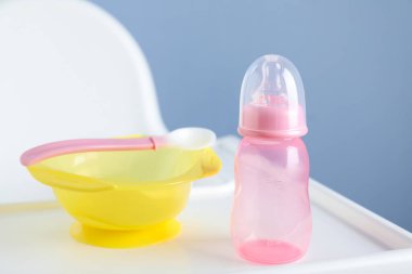 Beyaz beslenme masasında plastik bulaşık takımı. Bebek maması servisi.