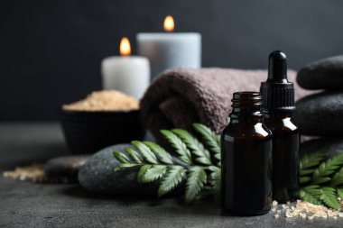 Gri masadaki aroma yağlı spa kompozisyonu, yakın plan. Metin için boşluk