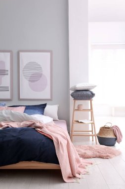 Odasında şık çarşaflar olan rahat bir yatak.