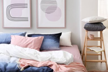 Odasında şık çarşaflar olan rahat bir yatak.