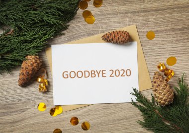 Metinli kart Elveda 2020 ve ahşap arka planda şenlikli dekor, düz yatış