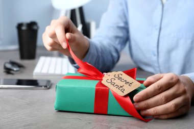 İş yerindeki gizli Noel Baba 'dan hediyeyi açan adam, yakın plan.