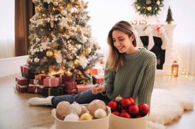 Evde Noel ağacı süsleyen güzel bir kadın.