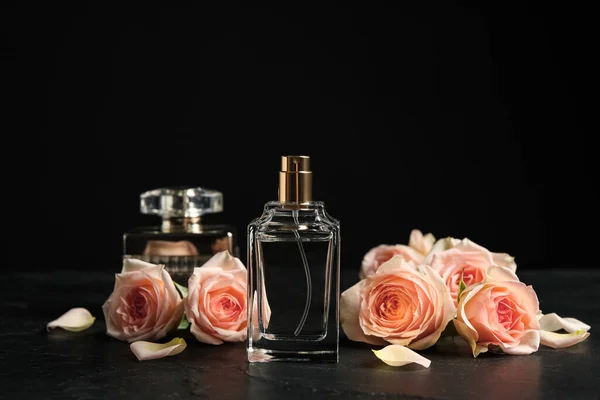 Eine Flasche Parfüm Und Schöne Rosen Auf Schwarzem Tisch — Stockfoto