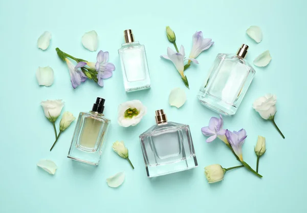 Flache Lagekomposition Mit Verschiedenen Parfümflaschen Und Blumen Auf Zyanischem Hintergrund — Stockfoto