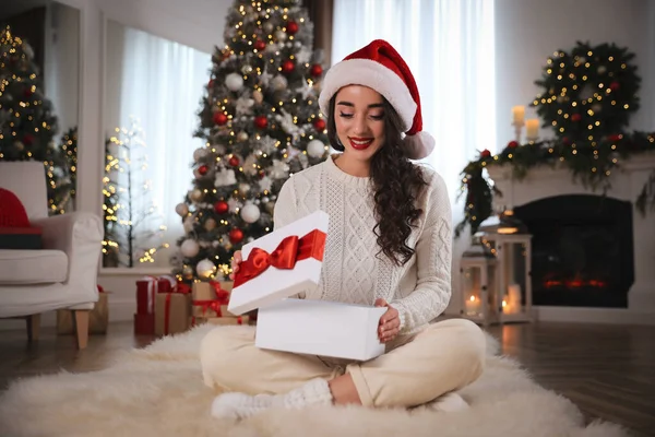 Noel Baba Şapkası Takan Genç Bir Kadın Noel Hediyesini Evde — Stok fotoğraf