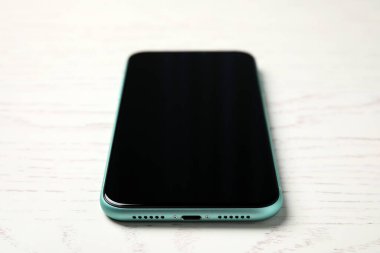 MYKOLAIV, UKRAINE - 10 Temmuz 2020: Beyaz ahşap masa üzerinde yeni modern Iphone 11, yakın plan