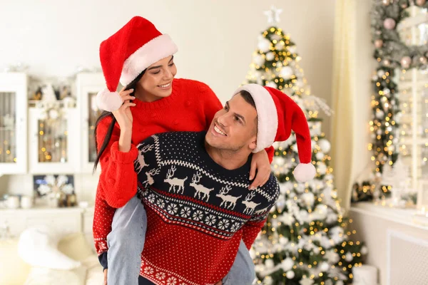 サンタの帽子の幸せなカップルは自宅で楽しんでいます クリスマスのお祝い — ストック写真