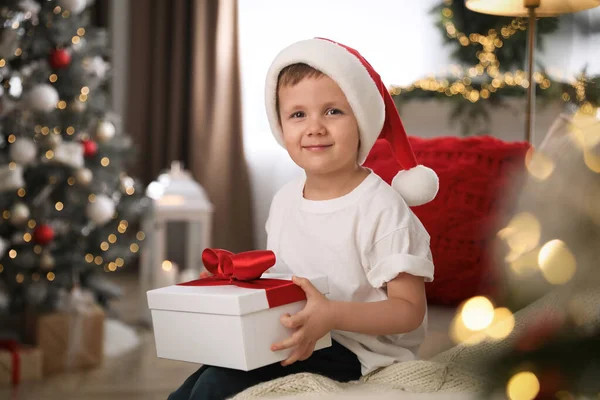 Schattig Jongetje Met Geschenkdoos Bank Kamer Ingericht Voor Kerstmis — Stockfoto