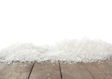 Beyaz arka plana karşı tahta yüzeyde kar. Noel sezonu