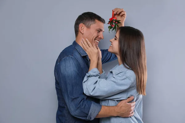 Coppia Felice Piedi Sotto Gruppo Vischio Sfondo Grigio — Foto Stock