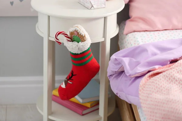 在儿童房的白色桌子上挂着礼物的长袜 圣尼古拉斯节传统 — 图库照片