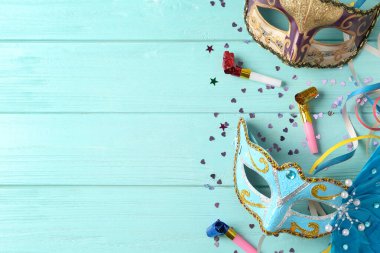 Güzel karnaval maskeleri ve açık mavi ahşap arka planda parti dekorasyonu, düz yatış. Metin için boşluk