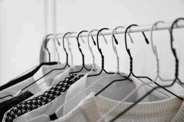 Beyaz duvarın yanında şık kıyafetlerle dizilin, yakın plan.