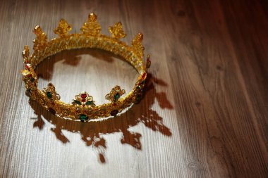 Tahta masasında mücevherler olan güzel altın taç. Fantezi ögesi