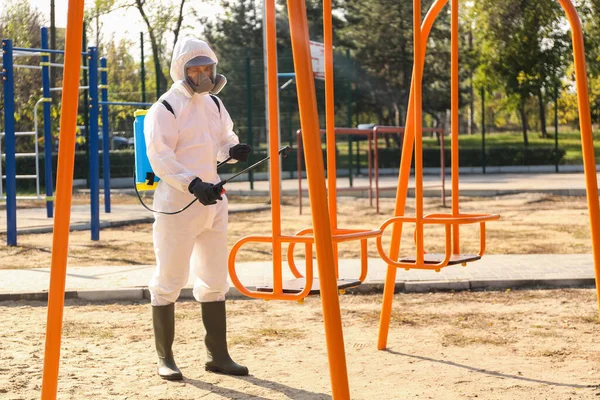 Hombre Traje Materiales Peligrosos Con Rociador Desinfectante Cerca Del Columpio — Foto de Stock