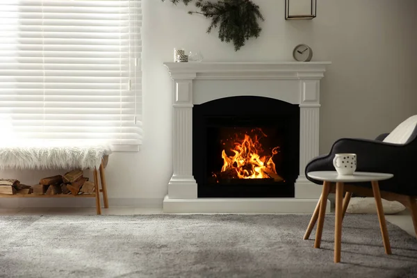 Bright living room interior with artificial fireplace and firewood