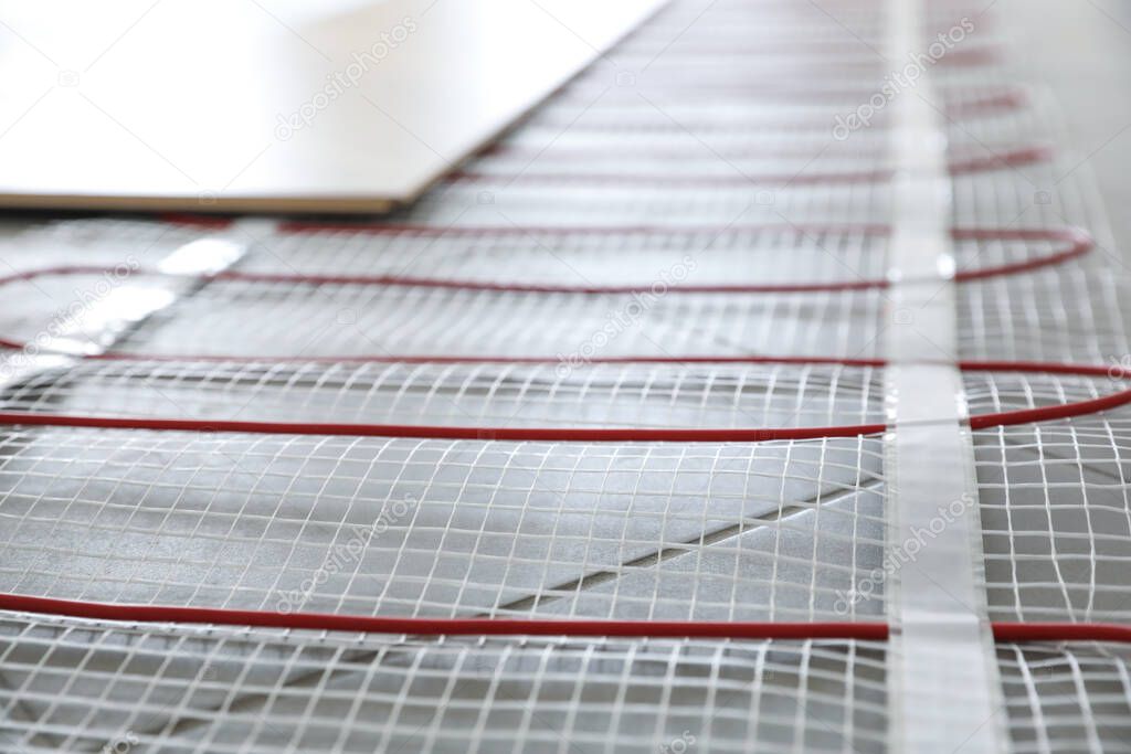 Installation of modern underfloor trace heating system indoors, closeup