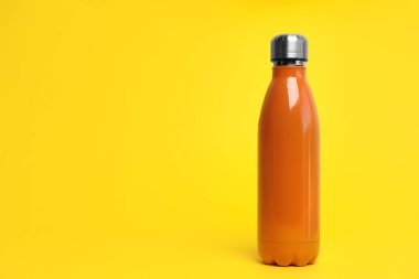 Sarı arkaplanda termo şişe, metin için boşluk