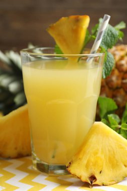 Bardakta nefis ananas suyu ve masada taze meyve, yakın plan.