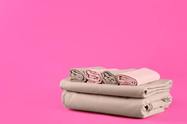 Pembe arka planda bir yığın temiz çarşaf. Metin için boşluk