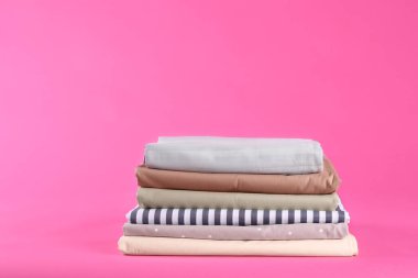 Pembe arka planda bir yığın temiz çarşaf. Metin için boşluk