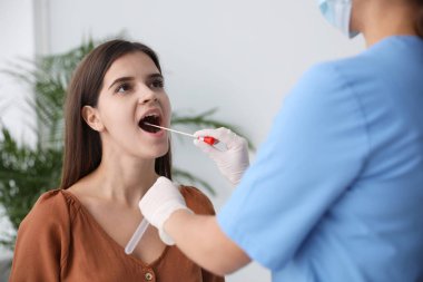 Doktor klinikteki kadından DNA testi için örnek alıyor.