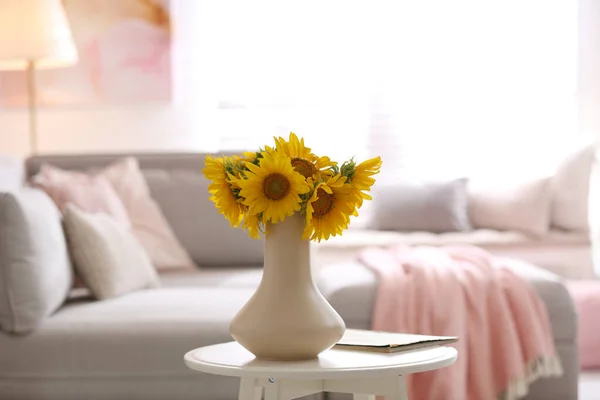 Beautiful bouquet of sunflowers in vase on white table indoors