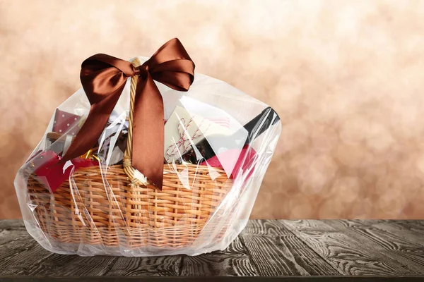 Wicker Basket Full Gifts Wooden Table Blurred Background Space Text — Stock Photo, Image