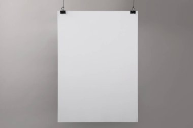 Gri duvarın yanında asılı beyaz boş poster