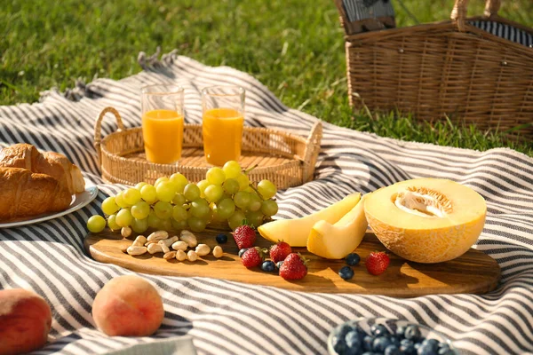 Picknickdecke Mit Leckerem Essen Und Saft Auf Grünem Gras — Stockfoto