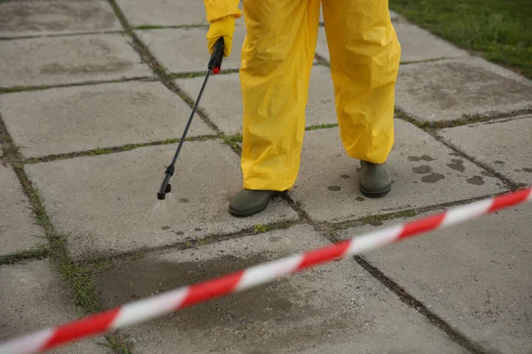 Persona Traje Materiales Peligrosos Desinfectando Pavimento Calle Con Rociador Primer —  Fotos de Stock