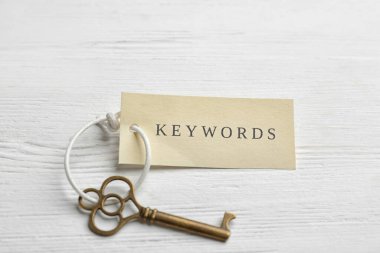Beyaz ahşap arkaplanda KEYWORDS etiketli anahtar