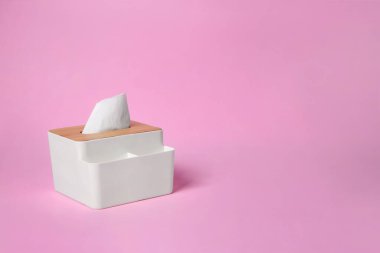 Pembe arka planda kağıt mendilleri olan tutucu. Metin için boşluk