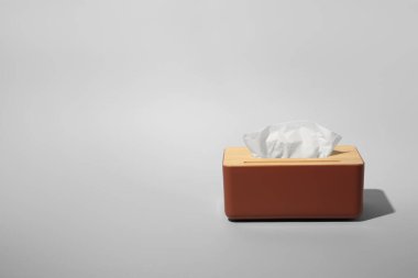 Açık gri arka planda kağıt mendilli tutucu. Metin için boşluk