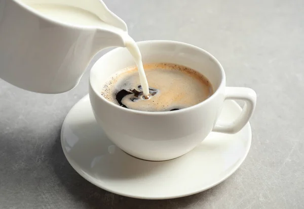 Melk Een Kopje Hete Koffie Een Grijze Tafel Gieten — Stockfoto