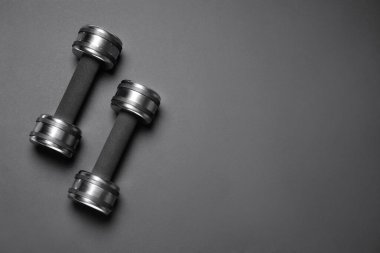 Siyah arka planda metal halterler, düz yatış. Metin için boşluk