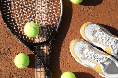 Tenis topları, raket ve ayakkabılar kil sahada, düz yerde