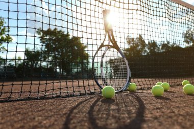 Tenis topları ve raketler kil sahada kalenin yanında
