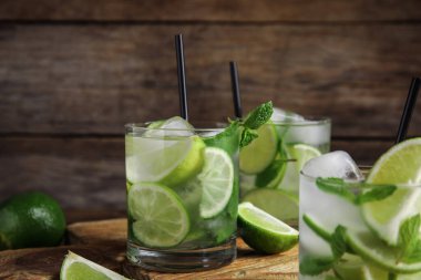 Lezzetli mojito ve ahşap masadaki malzemeler.