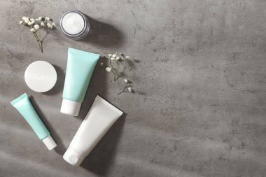 Gri masadaki lüks kozmetik ürünler. Metin için boşluk