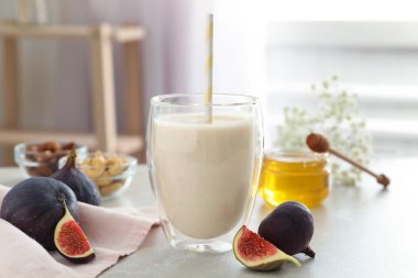 Işık masasının üzerinde cam içinde nefis incirli smoothie.