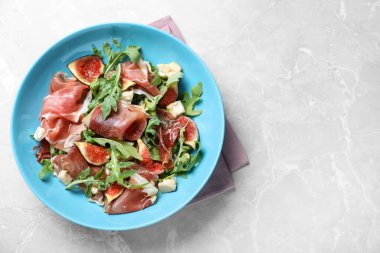 Gri mermer masada servis edilen, olgun incirli salata ve prosciutto. Metin için boşluk