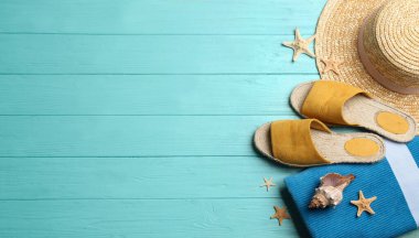 Açık mavi ahşap arka planda plaj aksesuarları, düz yatış. Metin için boşluk