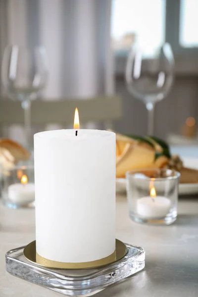 テーブルの上の白い燃えるワックスキャンドル — ストック写真