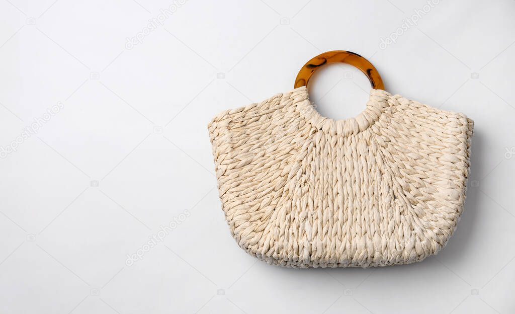 Stylish straw bag on white background, top view. Summer accessory