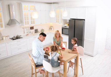 Modern mutfaktaki masada mutlu bir aile yemeği.