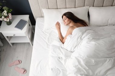 Yorgun bir kadın evde uyuyor, manzaranın üstünde.