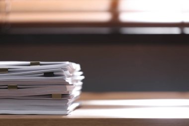 İçerideki ahşap masada ataçları olan boş kağıt yığını. Metin için boşluk